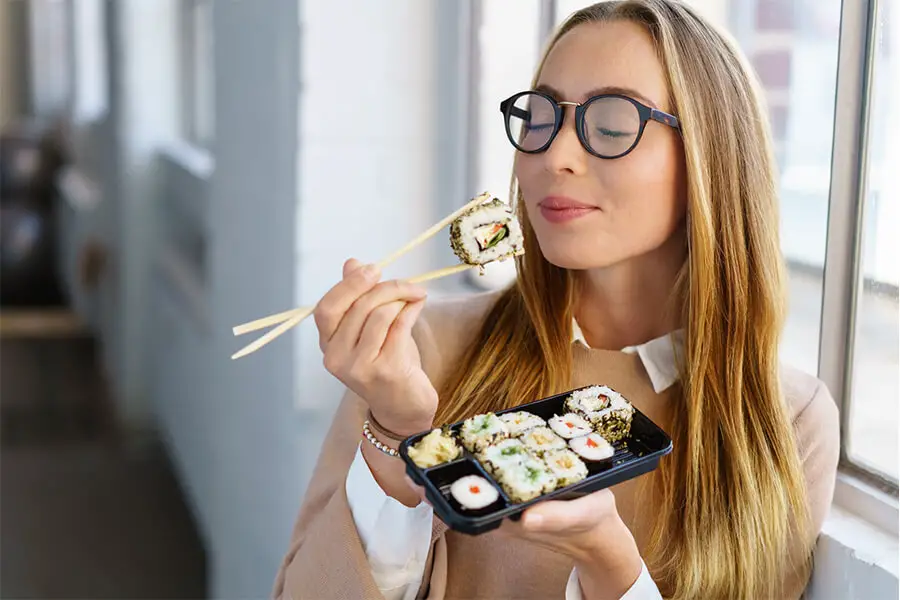 Femme mange sushis avec baguette